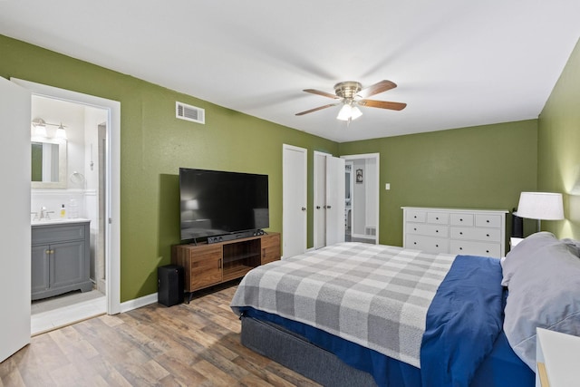 1701 W Birge St, Sherman, TX 75092 - bedroom featuring wood finished floors, baseboards, ceiling fan, a sink, and ensuite bath