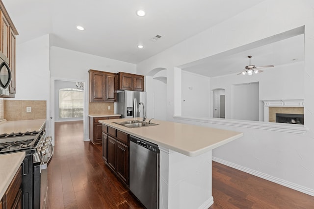 1716 Yarmouth Ln, Mansfield, TX 76063 - kitchen featuring arched walkways, appliances with stainless steel finishes, light countertops, a sink, and a ceiling fan