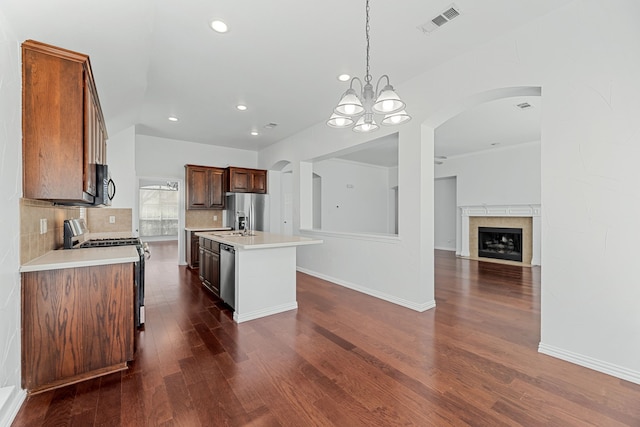 1716 Yarmouth Ln, Mansfield, TX 76063 - kitchen featuring pendant lighting, tasteful backsplash, appliances with stainless steel finishes, light countertops, and dark wood-type flooring