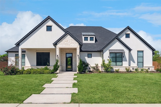 modern farmhouse style home featuring a front lawn, stucco siding, and stone siding