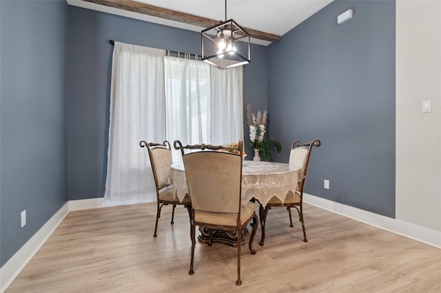 dining room with baseboards, wood finished floors, a notable chandelier, and beam ceiling