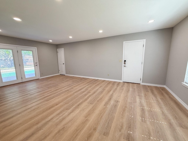 unfurnished living room featuring baseboards, recessed lighting, and light wood-style floors