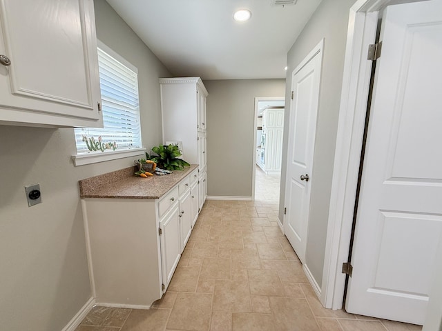 laundry area featuring hookup for an electric dryer, stone finish floor, visible vents, baseboards, and recessed lighting
