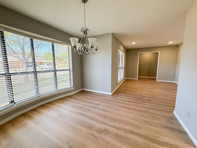 unfurnished dining area featuring a chandelier, baseboards, light wood-style flooring, and recessed lighting