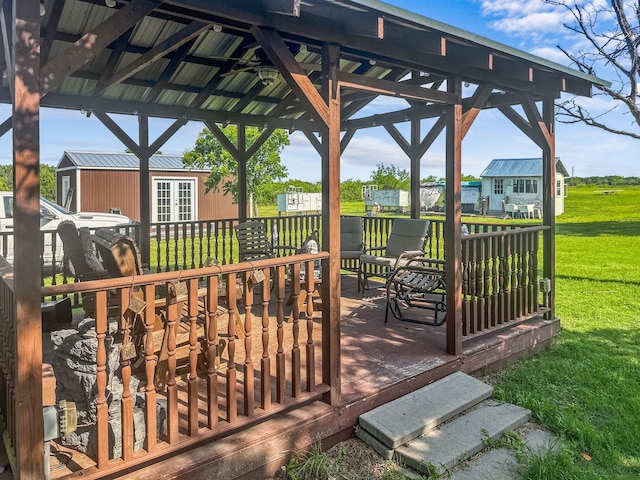 deck with a lawn, a gazebo, and an outdoor structure