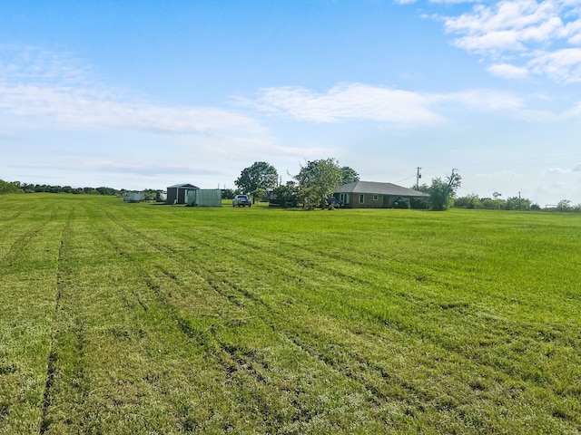 view of yard featuring a rural view and an outbuilding
