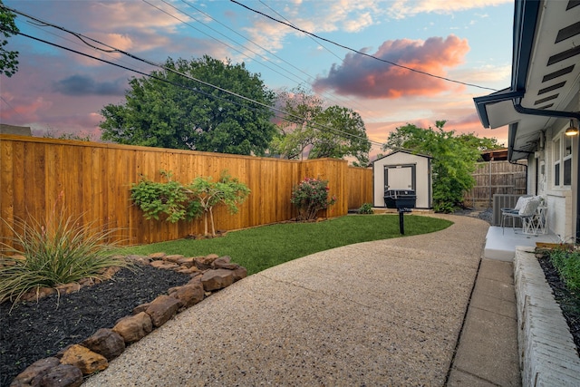 view of yard featuring an outdoor structure, a shed, a patio, and a fenced backyard