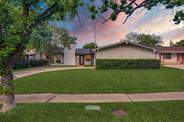 ranch-style house with a chimney and a front yard