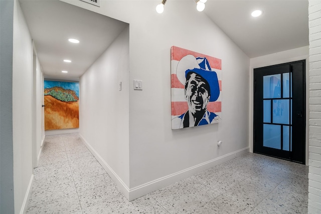 corridor with recessed lighting, lofted ceiling, and baseboards
