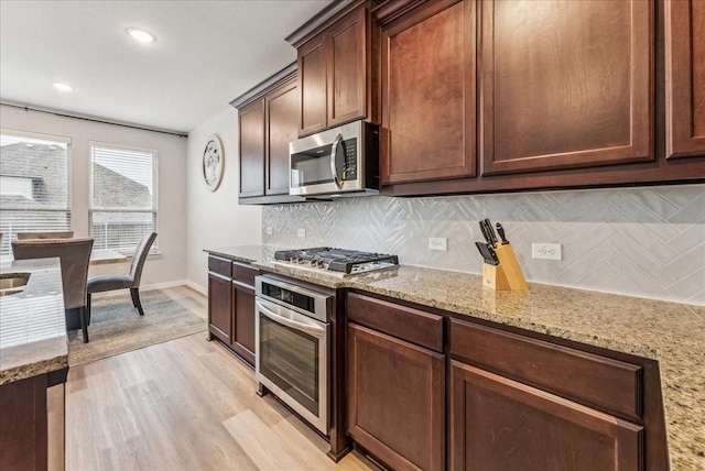 2203 Lannister St, Mansfield, TX 76063 - kitchen with light stone countertops, appliances with stainless steel finishes, light wood-style flooring, recessed lighting, and tasteful backsplash