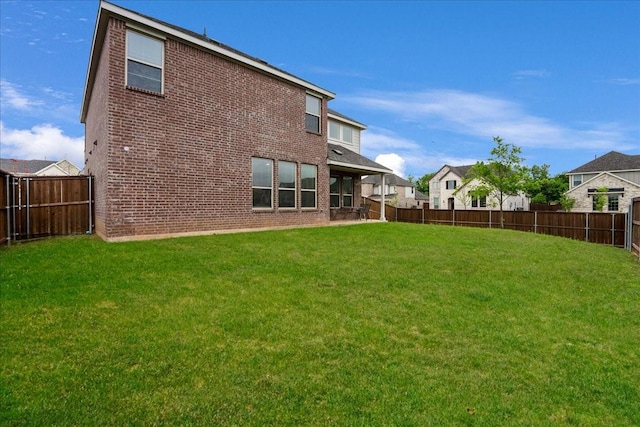 2203 Lannister St, Mansfield, TX 76063 - rear view of house featuring brick siding, a fenced backyard, and a lawn