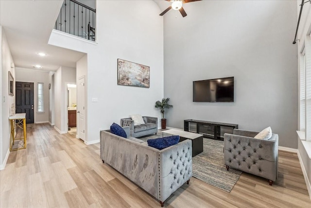 2203 Lannister St, Mansfield, TX 76063 - living room with baseboards, ceiling fan, light wood-style flooring, and a towering ceiling
