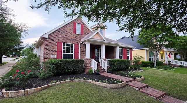 bungalow-style house with brick siding, a front yard, and a porch