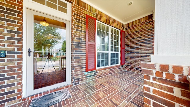property entrance featuring brick siding and covered porch