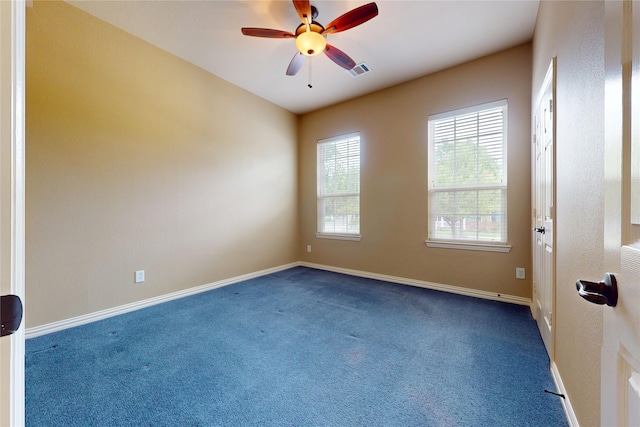 carpeted spare room featuring baseboards, ceiling fan, and visible vents