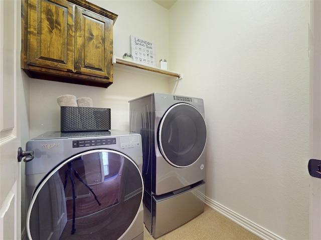 laundry area featuring cabinet space, baseboards, and washer and dryer