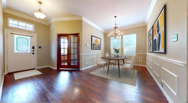 entrance foyer featuring crown molding, a wealth of natural light, a chandelier, and a decorative wall