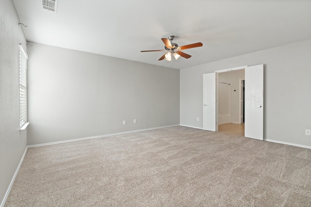 unfurnished room with baseboards, visible vents, a ceiling fan, and light colored carpet