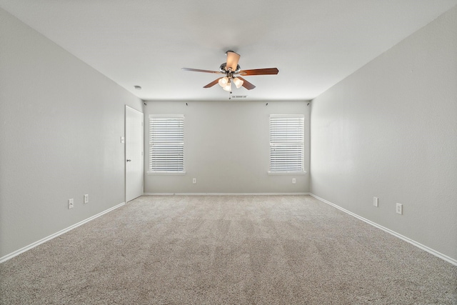 empty room with baseboards, visible vents, a ceiling fan, and carpet flooring