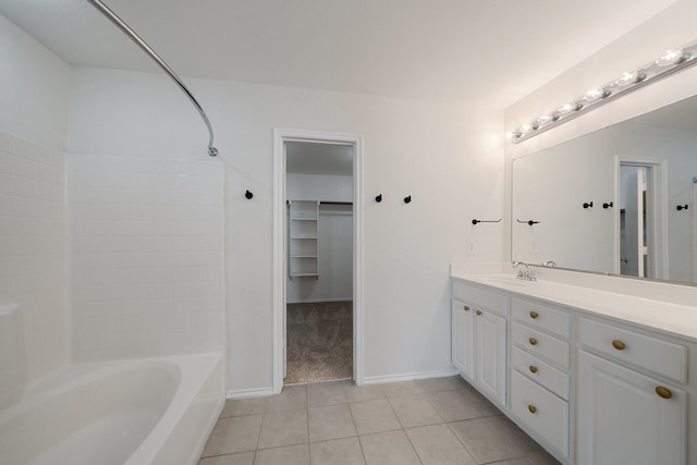 bathroom with tile patterned floors, shower / bathing tub combination, vanity, baseboards, and a spacious closet