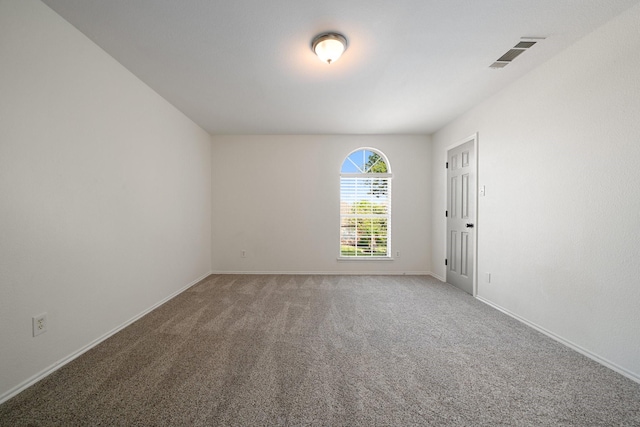 carpeted empty room with visible vents and baseboards