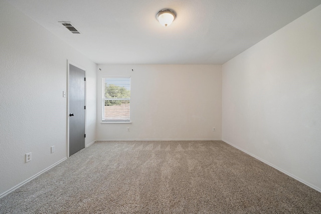 unfurnished room featuring baseboards, visible vents, and light colored carpet
