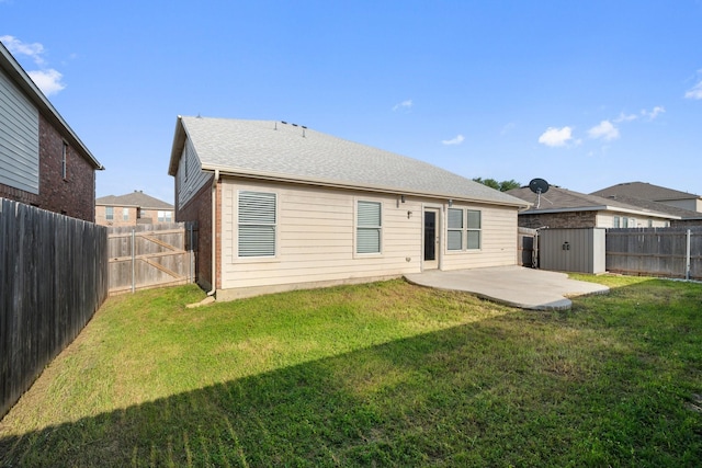 rear view of property with a patio, a lawn, and a fenced backyard