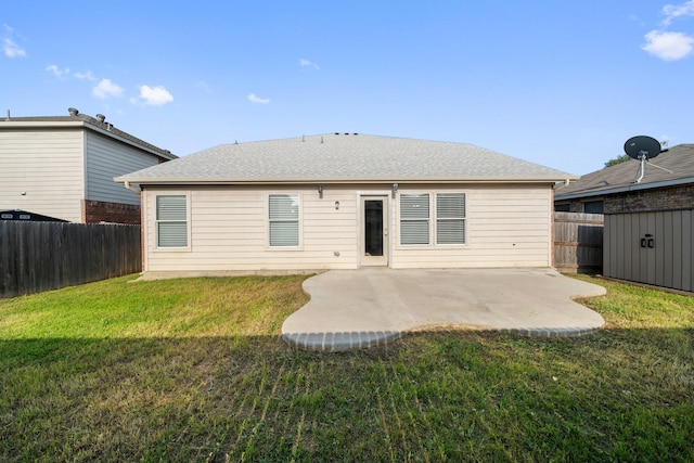back of property with an outdoor structure, a fenced backyard, roof with shingles, a patio area, and a lawn