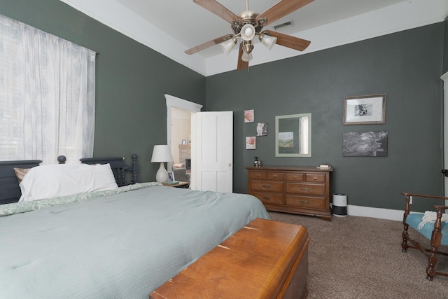 carpeted bedroom featuring a ceiling fan, visible vents, and baseboards