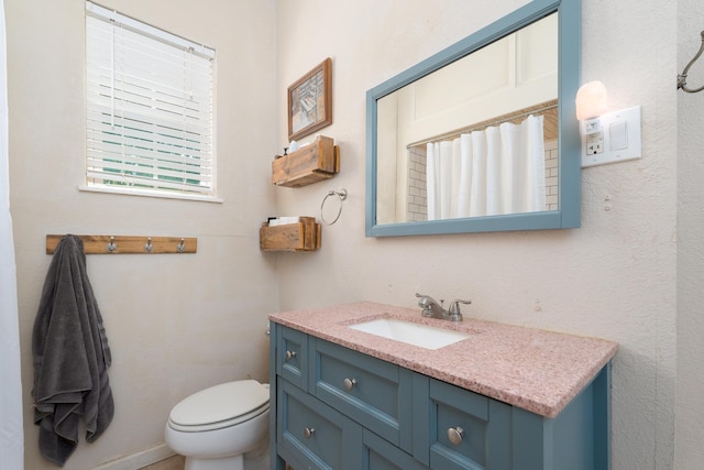 bathroom with toilet, curtained shower, and vanity