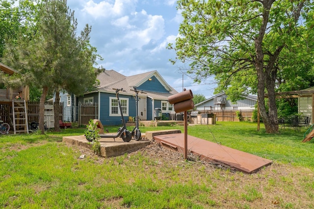 back of house featuring fence and a lawn