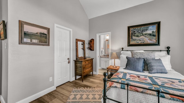 bedroom with high vaulted ceiling, baseboards, ensuite bath, and light wood-type flooring