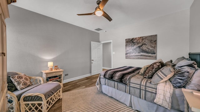 bedroom featuring baseboards, visible vents, wood finished floors, and ceiling fan