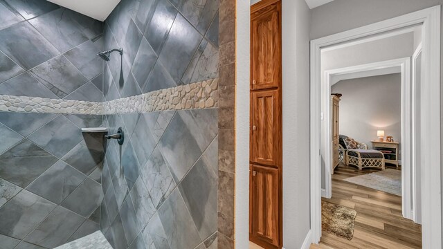 bathroom featuring tiled shower and wood finished floors