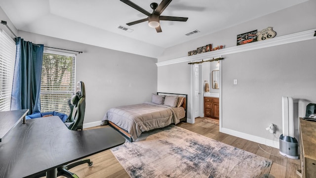 bedroom with baseboards, visible vents, light wood-style floors, and vaulted ceiling