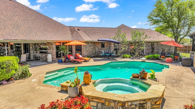 view of swimming pool featuring a pool with connected hot tub and a patio area