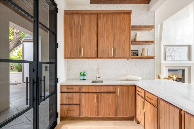 6814 Glendora Ave, Dallas, TX 75230 - kitchen featuring open shelves, decorative backsplash, a sink, and french doors
