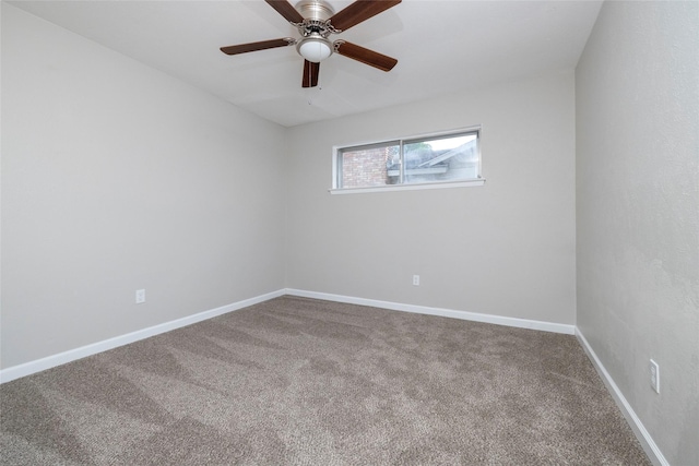 carpeted spare room with ceiling fan and baseboards