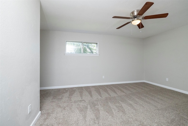 carpeted empty room with baseboards and ceiling fan