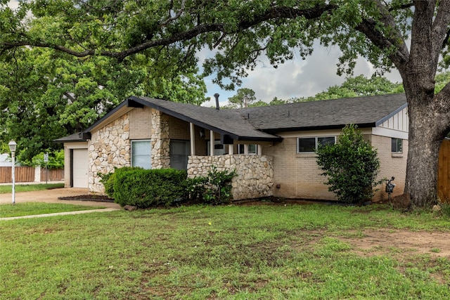 ranch-style house with driveway, fence, a front lawn, an attached garage, and stone siding