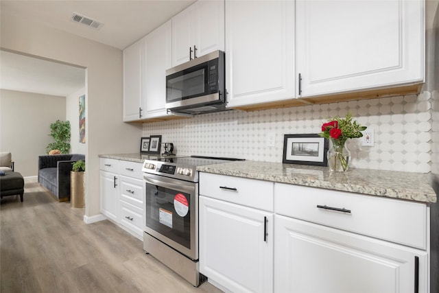 kitchen featuring visible vents, decorative backsplash, light wood-style floors, white cabinetry, and stainless steel appliances