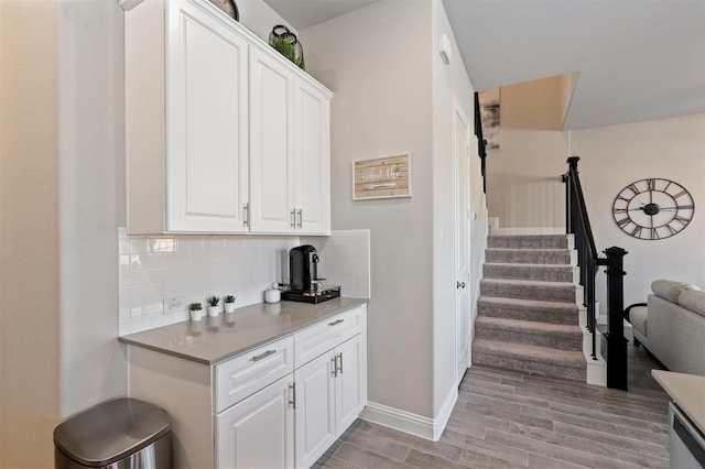 6246 Rilla St, Frisco, TX 75035 - bar with light wood-style floors, baseboards, stairs, and backsplash