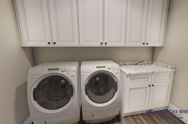 washroom featuring baseboards, separate washer and dryer, and cabinet space