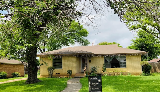 view of front facade with brick siding and a front yard