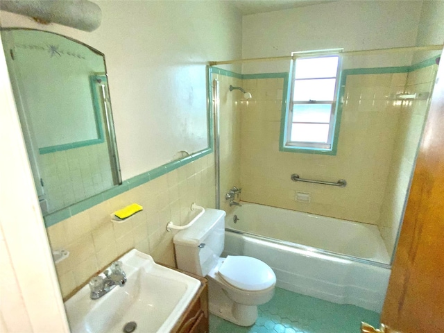 bathroom featuring tile walls, toilet, shower / bathtub combination, and a sink