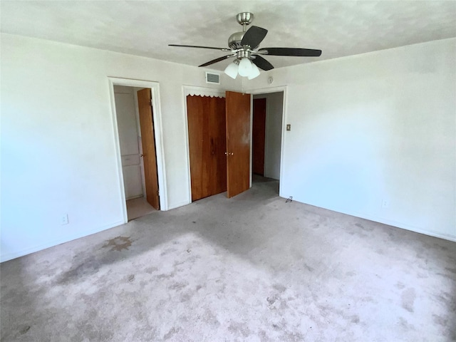 unfurnished bedroom featuring visible vents, ceiling fan, and light carpet
