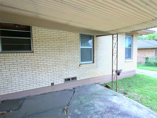 view of property exterior featuring a patio and brick siding