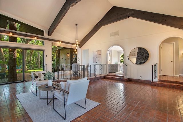 living area featuring arched walkways, high vaulted ceiling, visible vents, and brick floor