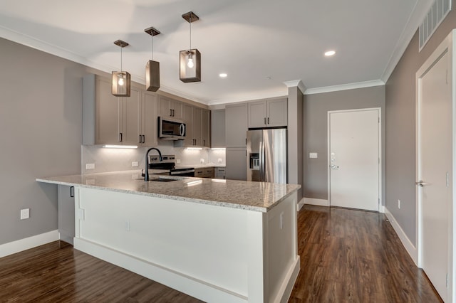 kitchen featuring decorative backsplash, stainless steel appliances, a sink, gray cabinetry, and a peninsula