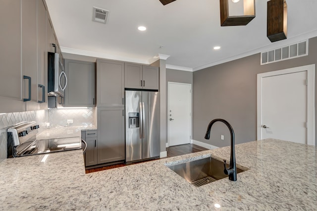 kitchen featuring crown molding, a sink, stainless steel appliances, dark wood-style flooring, and gray cabinets